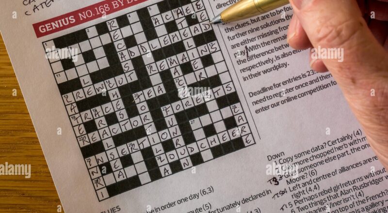 Solving Complicated Crossword Puzzle In The Guardian Newspaper Called Genius By Crossword Setter Nom De Plume Boatman With Man s Hand Holding Pen Stock Photo Alamy