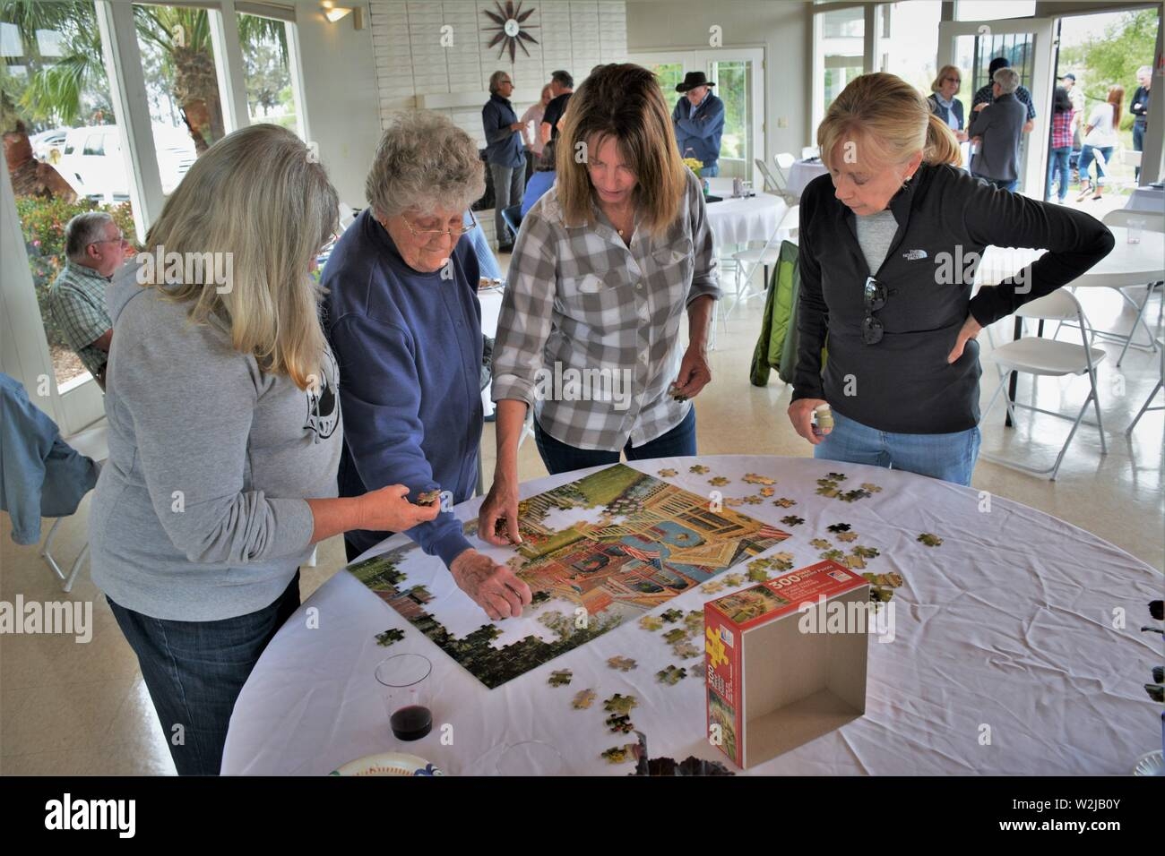 Women From Real Family At Gathering Doing Crossword Puzzle Mother At 90 And 2 Daughters And In Laws At Barbecue Having Fun Together Stock Photo Alamy
